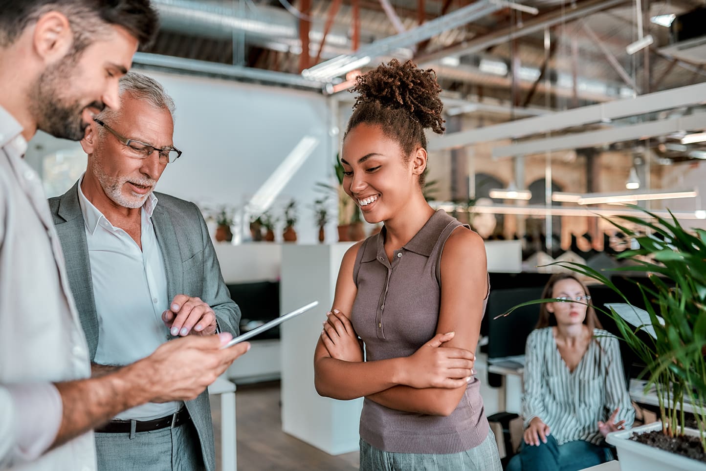2 mannen en een vrouw in overleg kijken op een tablet
