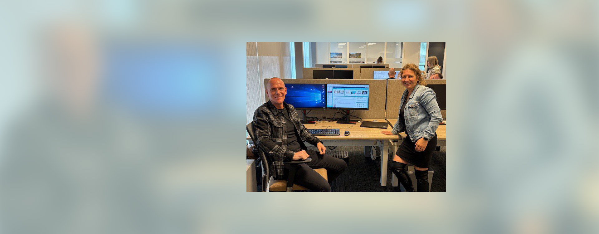 man en vrouw achter bureau kijken in camera