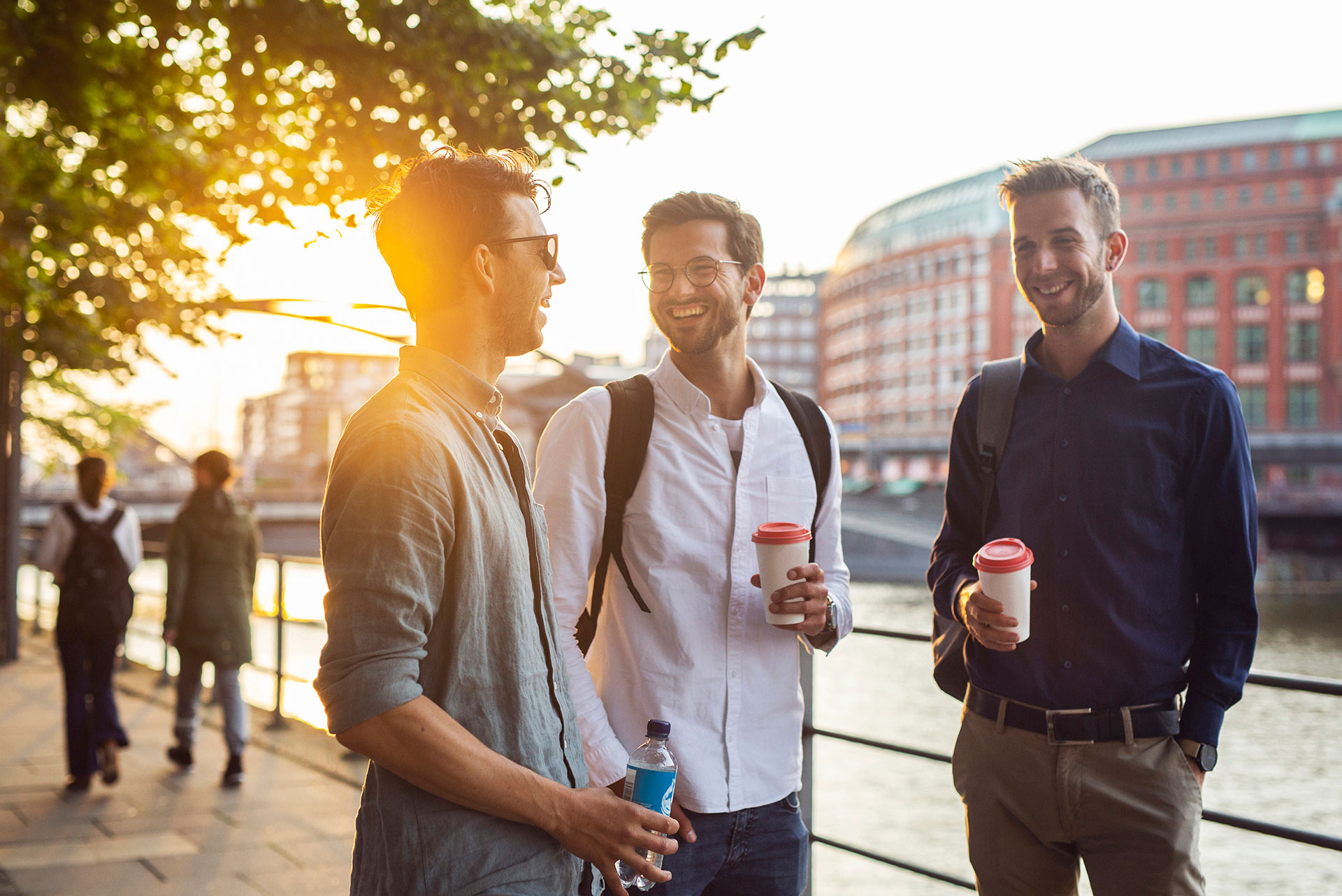 drie mannen lachend onderweg naar kantoor