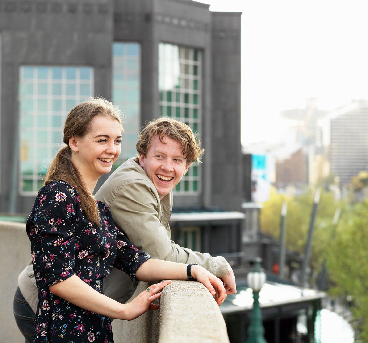 vrouw en man lachend op balkon van kantoor