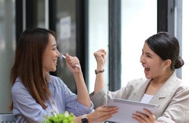 twee vrouwen vrolijk op kantoor