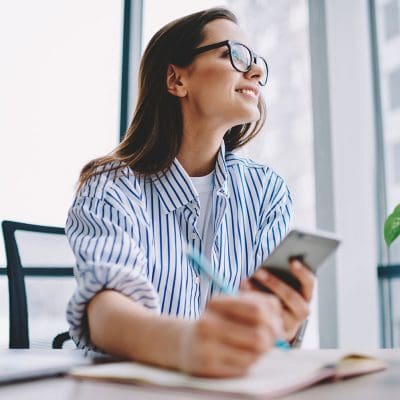 vrouw met smartphone en notitieblok