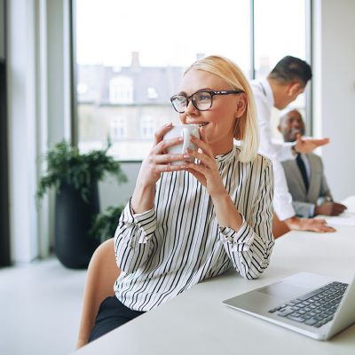 vrouw met laptop drinkt water